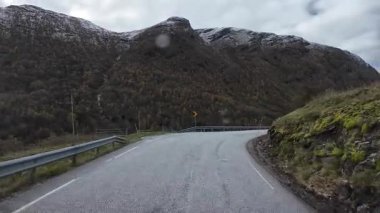 Bakış açısı, güneşli bir günde Norveç 'te bir sahil yolunda bir karavan sürerken çekilmiş.