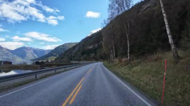 Bakış açısı, güneşli bir günde Norveç 'te bir sahil yolunda bir karavan sürerken çekilmiş.