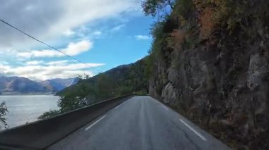 Bakış açısı, güneşli bir günde Norveç 'te bir sahil yolunda bir karavan sürerken çekilmiş.