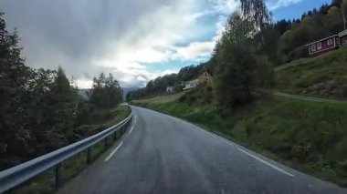 Bakış açısı, güneşli bir günde Norveç 'te bir sahil yolunda bir karavan sürerken çekilmiş.