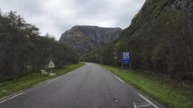 Bakış açısı, güneşli bir günde Norveç 'te bir sahil yolunda bir karavan sürerken çekilmiş.