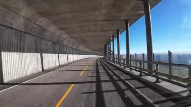 Güneşli bir günde Lofoten Adaları 'nın güzel manzarası olan bir dağ yolunda karavanla yolculuk yapmak.