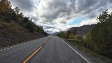 Güneşli bir günde Lofoten Adaları 'nın güzel manzarası olan bir dağ yolunda karavanla yolculuk yapmak.