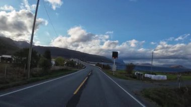 Güneşli bir günde Lofoten Adaları 'nın güzel manzarası olan bir dağ yolunda karavanla yolculuk yapmak.