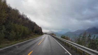 Güneşli bir günde Lofoten Adaları 'nın güzel manzarası olan bir dağ yolunda karavanla yolculuk yapmak.