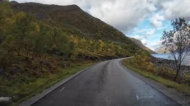 Güneşli bir günde Lofoten Adaları 'nın güzel manzarası olan bir dağ yolunda karavanla yolculuk yapmak.