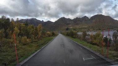 Güneşli bir günde Lofoten Adaları 'nın güzel manzarası olan bir dağ yolunda karavanla yolculuk yapmak.