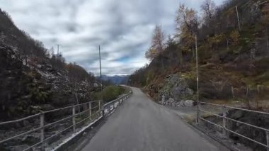 Güneşli bir günde Lofoten Adaları 'nın güzel manzarası olan bir dağ yolunda karavanla yolculuk yapmak.