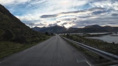 Lofoten Adaları, Norveç; 11 Eylül 2024: Lofoten 'de dağlarla ve fiyortlarla çarpıcı bir sahil yolu boyunca araba sürerken çekilen görüntüler