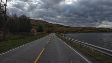 Lofoten Adaları, Norveç; 11 Eylül 2024: Lofoten 'de dağlarla ve fiyortlarla çarpıcı bir sahil yolu boyunca araba sürerken çekilen görüntüler