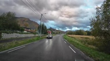 Lofoten Adaları, Norveç; 11 Eylül 2024: Lofoten 'de dağlarla ve fiyortlarla çarpıcı bir sahil yolu boyunca araba sürerken çekilen görüntüler