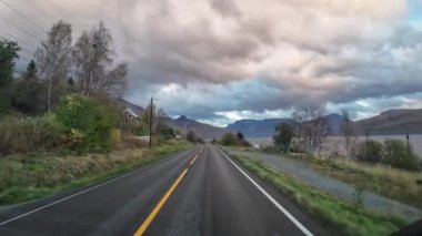 Lofoten Adaları, Norveç; 11 Eylül 2024: Lofoten 'de dağlarla ve fiyortlarla çarpıcı bir sahil yolu boyunca araba sürerken çekilen görüntüler