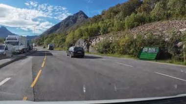 Lofoten Adaları, Norveç; 11 Eylül 2024: Lofoten 'de dağlarla ve fiyortlarla çarpıcı bir sahil yolu boyunca araba sürerken çekilen görüntüler