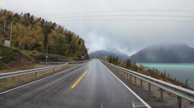 Lofoten Adaları, Norveç; 11 Eylül 2024: Lofoten 'de dağlarla ve fiyortlarla çarpıcı bir sahil yolu boyunca araba sürerken çekilen görüntüler