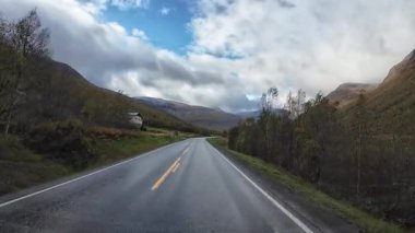 Lofoten Adaları, Norveç; 11 Eylül 2024: Lofoten 'de dağlarla ve fiyortlarla çarpıcı bir sahil yolu boyunca araba sürerken çekilen görüntüler