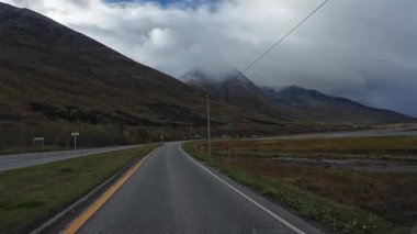 Lofoten Adaları, Norveç; 11 Eylül 2024: Lofoten 'de dağlarla ve fiyortlarla çarpıcı bir sahil yolu boyunca araba sürerken çekilen görüntüler