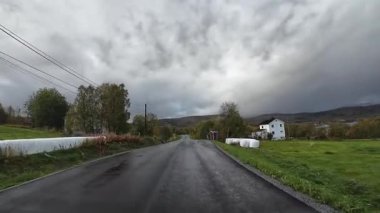 Lofoten Adaları, Norveç; 11 Eylül 2024: Lofoten 'de dağlarla ve fiyortlarla çarpıcı bir sahil yolu boyunca araba sürerken çekilen görüntüler