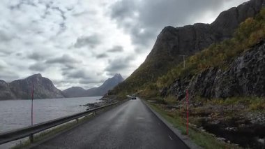 Lofoten Adaları, Norveç; 11 Eylül 2024: Lofoten 'de dağlarla ve fiyortlarla çarpıcı bir sahil yolu boyunca araba sürerken çekilen görüntüler