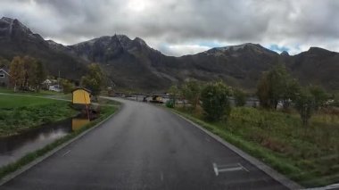 Lofoten Adaları, Norveç; 11 Eylül 2024: Lofoten 'de dağlarla ve fiyortlarla çarpıcı bir sahil yolu boyunca araba sürerken çekilen görüntüler