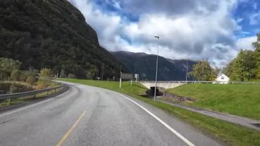 Lofoten Adaları, Norveç; 11 Eylül 2024: Lofoten 'de dağlarla ve fiyortlarla çarpıcı bir sahil yolu boyunca araba sürerken çekilen görüntüler