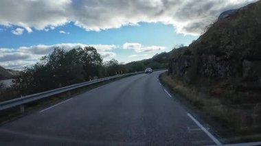 Lofoten Adaları, Norveç; 11 Eylül 2024: Güneşli bir günde Norveç 'te manzaralı bir yolda giden bir karavanın bakış açısı