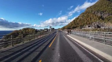 Lofoten Adaları, Norveç; 11 Eylül 2024: Güneşli bir günde Norveç 'te manzaralı bir yolda giden bir karavanın bakış açısı