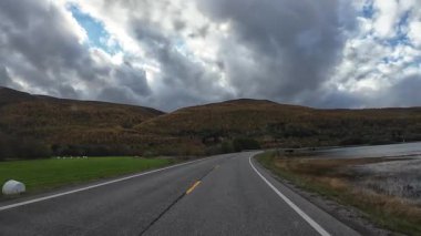 Lofoten Adaları, Norveç; 11 Eylül 2024: Güneşli bir günde Norveç 'te manzaralı bir yolda giden bir karavanın bakış açısı