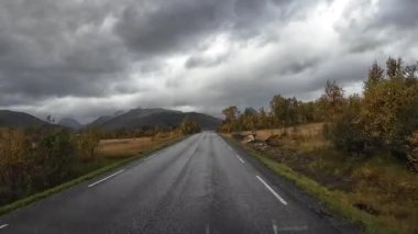 Lofoten Adaları, Norveç; 11 Eylül 2024: Güneşli bir günde Norveç 'te manzaralı bir yolda giden bir karavanın bakış açısı