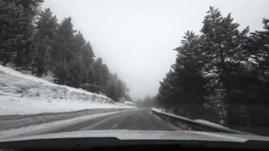 İspanya 'nın La Molina şehrinde kış boyunca virajlı ve karlı bir yolda giden bir arabadan bakış açısı