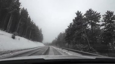 İspanya 'nın La Molina şehrinde kış boyunca virajlı ve karlı bir yolda giden bir arabadan bakış açısı