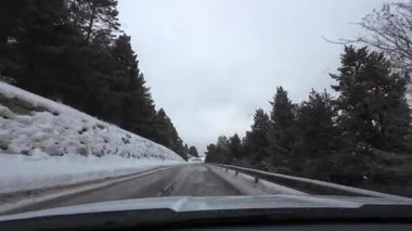 İspanya 'nın La Molina şehrinde kış boyunca virajlı ve karlı bir yolda giden bir arabadan bakış açısı