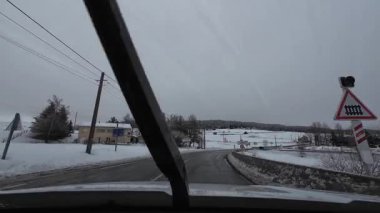 İspanya 'nın La Molina şehrinde kış boyunca virajlı ve karlı bir yolda giden bir arabadan bakış açısı