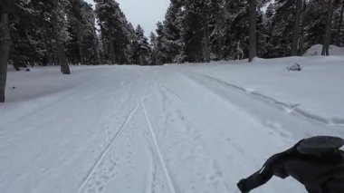 İspanya 'nın La Molina şehrinde kış boyunca virajlı ve karlı bir yolda giden bir arabadan bakış açısı