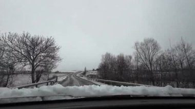 İspanya 'nın La Molina şehrinde kış boyunca virajlı ve karlı bir yolda giden bir arabadan bakış açısı