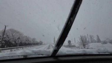 İspanya 'nın La Molina şehrinde kış boyunca virajlı ve karlı bir yolda giden bir arabadan bakış açısı