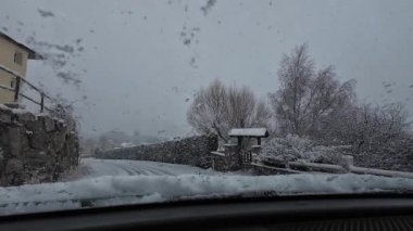 İspanya 'nın La Molina şehrinde kış boyunca virajlı ve karlı bir yolda giden bir arabadan bakış açısı