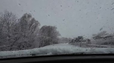 İspanya 'nın La Molina şehrinde kış boyunca virajlı ve karlı bir yolda giden bir arabadan bakış açısı