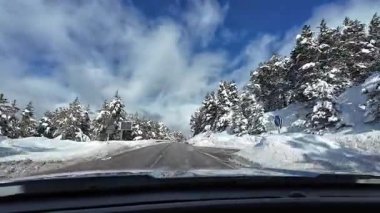 İspanya 'nın La Molina şehrinde kış boyunca virajlı ve karlı bir yolda giden bir arabadan bakış açısı