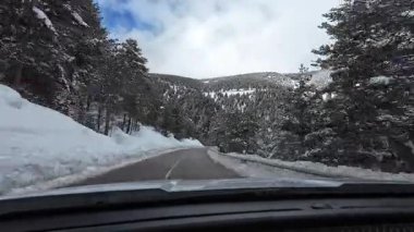 İspanya 'nın La Molina şehrinde kış boyunca virajlı ve karlı bir yolda giden bir arabadan bakış açısı