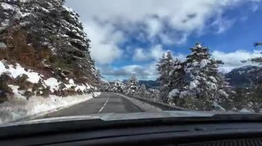 İspanya 'nın La Molina şehrinde kış boyunca virajlı ve karlı bir yolda giden bir arabadan bakış açısı