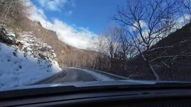 İspanya 'nın La Molina şehrinde kış boyunca virajlı ve karlı bir yolda giden bir arabadan bakış açısı