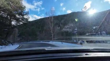 İspanya 'nın La Molina şehrinde kış boyunca virajlı ve karlı bir yolda giden bir arabadan bakış açısı