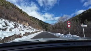 İspanya 'nın La Molina şehrinde kış boyunca virajlı ve karlı bir yolda giden bir arabadan bakış açısı