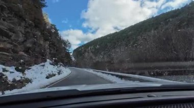 İspanya 'nın La Molina şehrinde kış boyunca virajlı ve karlı bir yolda giden bir arabadan bakış açısı