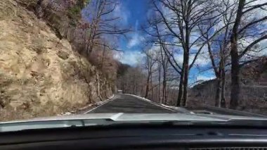 İspanya 'nın La Molina şehrinde kış boyunca virajlı ve karlı bir yolda giden bir arabadan bakış açısı