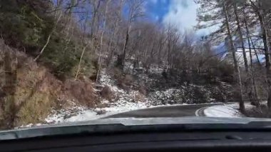 İspanya 'nın La Molina şehrinde kış boyunca virajlı ve karlı bir yolda giden bir arabadan bakış açısı