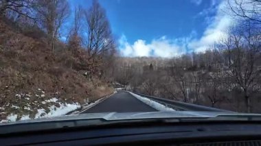 İspanya 'nın La Molina şehrinde kış boyunca virajlı ve karlı bir yolda giden bir arabadan bakış açısı