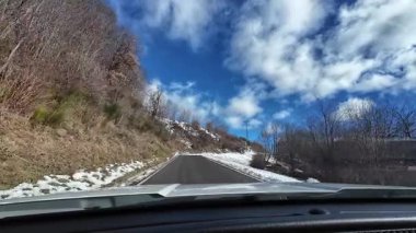 İspanya 'nın La Molina şehrinde kış boyunca virajlı ve karlı bir yolda giden bir arabadan bakış açısı