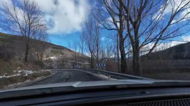 İspanya 'nın La Molina şehrinde kış boyunca virajlı ve karlı bir yolda giden bir arabadan bakış açısı