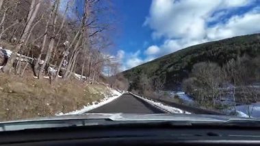 İspanya 'nın La Molina şehrinde kış boyunca virajlı ve karlı bir yolda giden bir arabadan bakış açısı